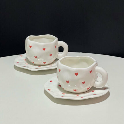Niedliches hand kneifen des unregelmäßig lackiertes kleines rotes Kaffee-Set